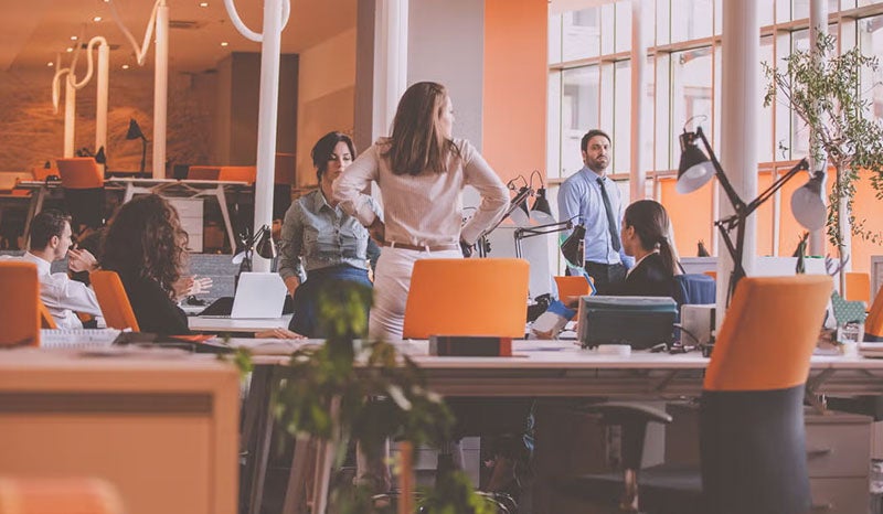 A vibrant office with a team discussing and collaborating on ideas.
