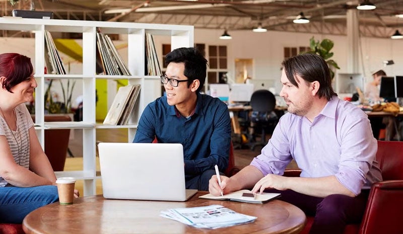 A group of people discussing ideas in an office meeting.