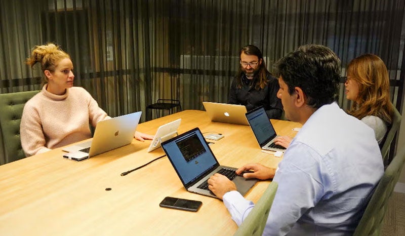A team of professionals working together in a modern conference room.