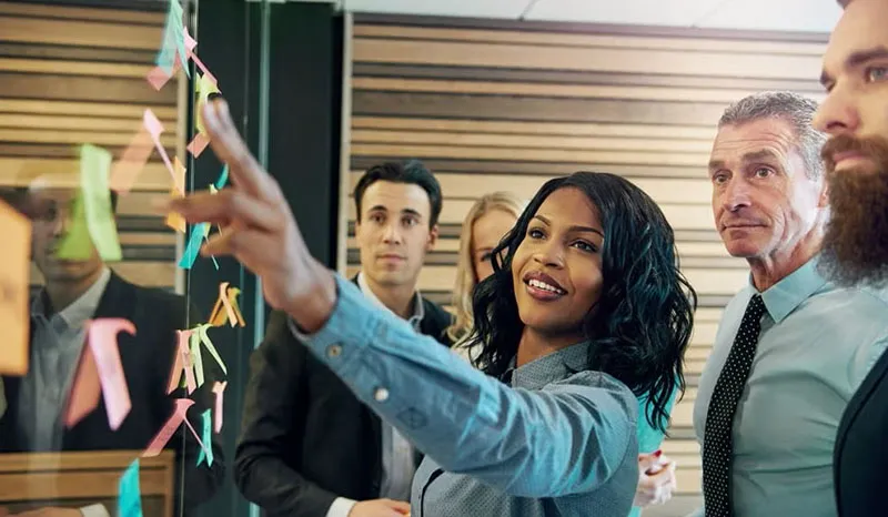 A team leader presenting ideas to colleagues during a meeting.